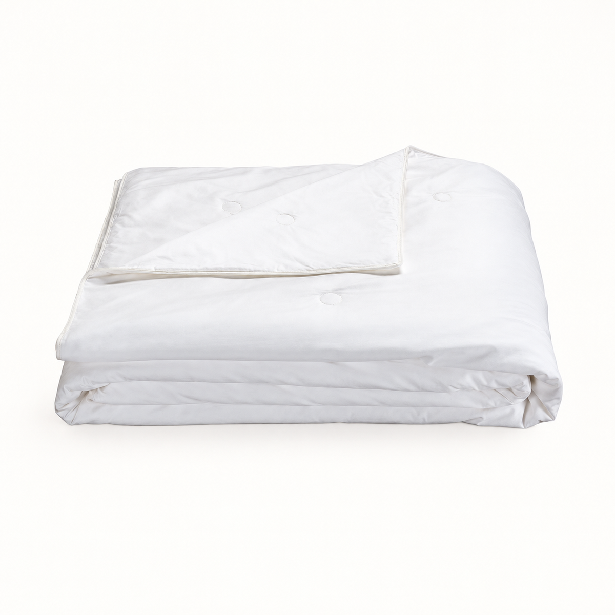 Folded white silk duvet insert on a white background